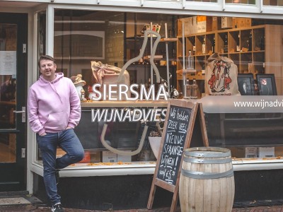 Rutger Siersma voor de etalage van zijn wijnwinkel in Baarn