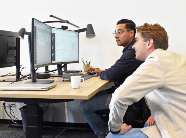 Twee medewerkers van PrismaFleet die samen naar een computerscherm kijken